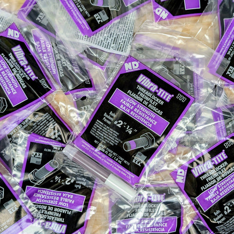 Multiple packages of Vibra-Tite thread locker with purple and black labels.